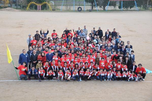 運動場に参加者が一同に集まり、高いところから全体を写している集合写真